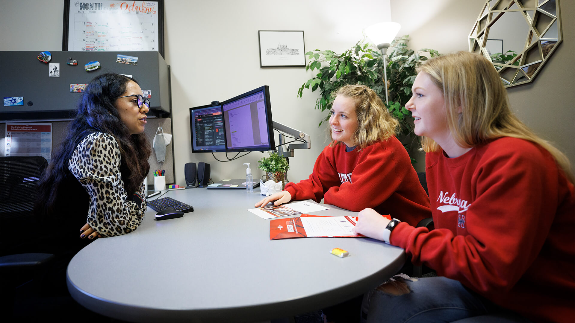 Students talking to advisor in office