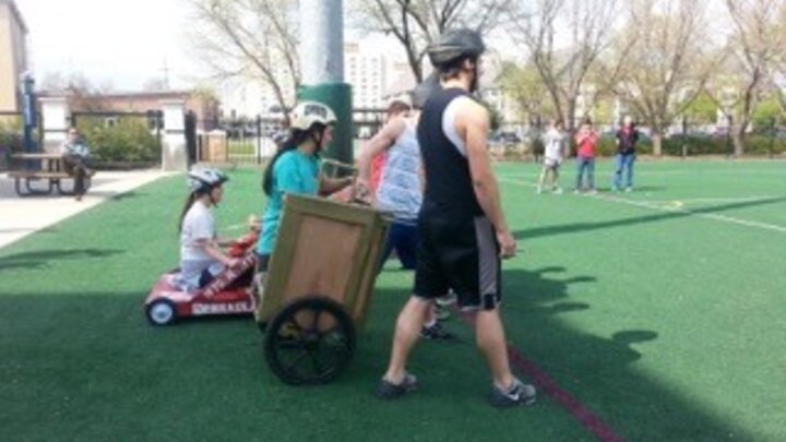 A group getting ready to pull a woman in a chariot 