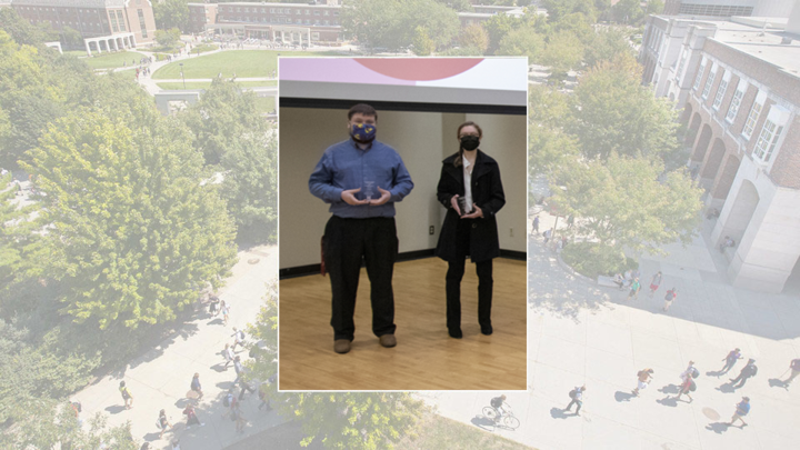 Two students holding awards