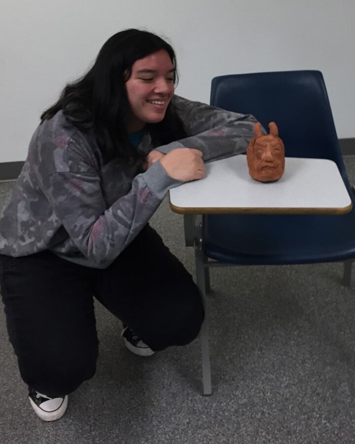 Students smile with their creative sculpture